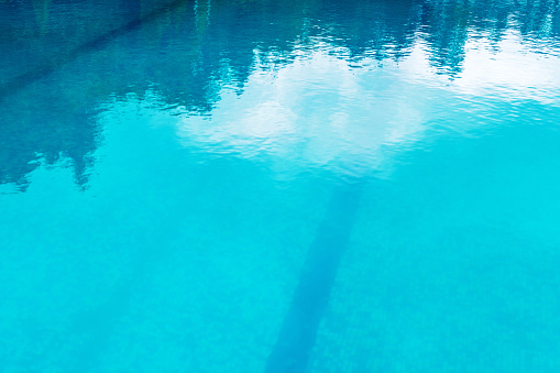 Blue swimming pool water as background with reflections