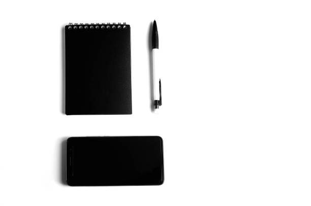 istock Black and white concept. Business concept with mobile phone, notebook and pen on a white background. 1167621460