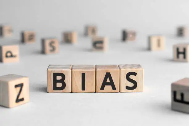 Bias - word from wooden blocks with letters, personal opinions prejudice bias concept, random letters around, white  background