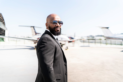 Portrait of businessman standing in front of corporate jet