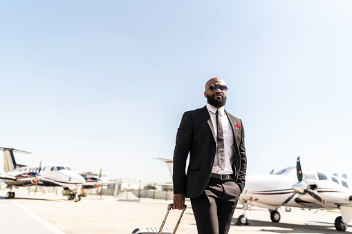 Portrait of businessman standing in front of corporate jet