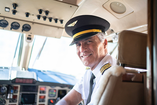 Portrait of airplane pilot looking over shoulder in a private jet