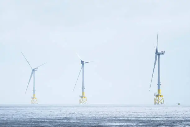 Wind turbines at electric power farm in the North Sea in Aberdeen for renewable energy production and environment conservation uk