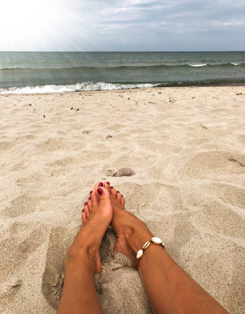 istock Women's sexy legs on the beach 1167630239