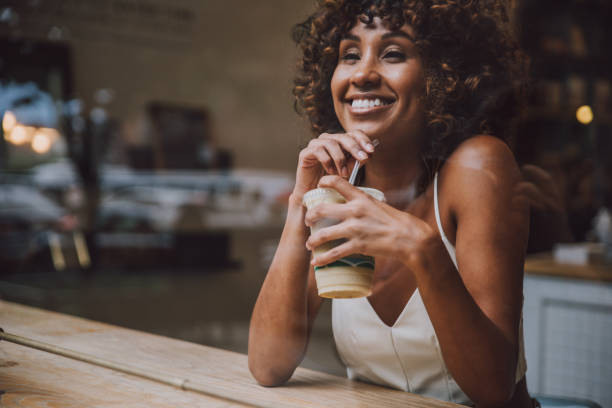 istock Beautful woman having a drink inside a cafe, view through the screen 1167631957