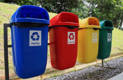 Selective garbage (paper, plastic, metal and glass, from left to right), written in portuguese