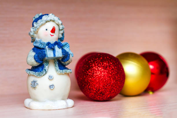 istock Christmas toys, ceramic snowman and tree balls on beige background. Selective focus 1167632649