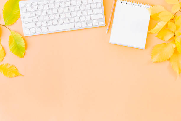 istock Flat lay blogger or freelancer workspace with a notebook, keyboard, colorful autumn leaves on a color background 1167633957