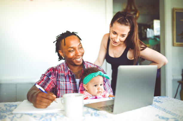istock African American dad works on a computer with his infant daughter with mom family using computer 1167634092