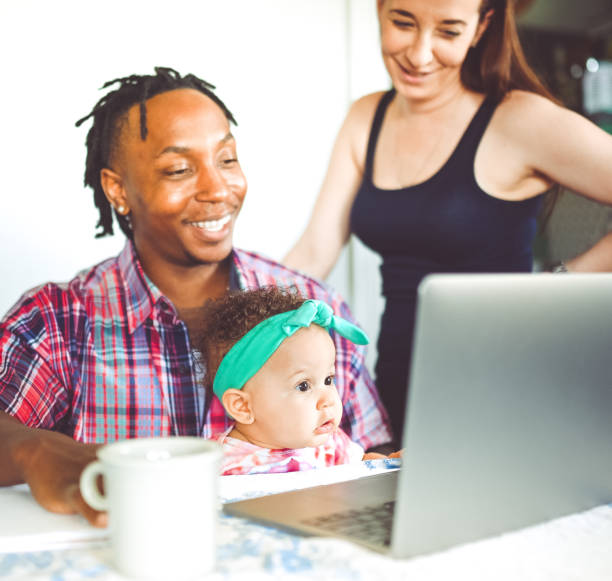 istock African American dad works on a computer with his infant daughter with mom family using computer 1167634096