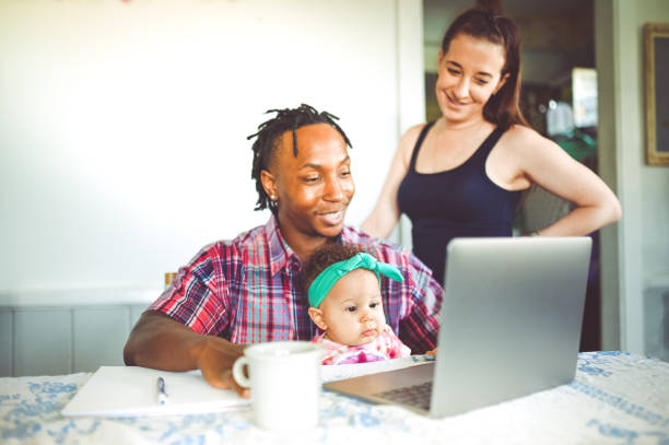 istock African American dad works on a computer with his infant daughter with mom family using computer 1167634100
