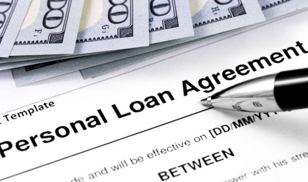 istock personal loan agreement application form with pen and money, dollars 1167634543