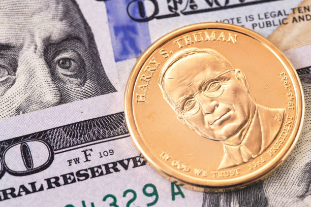 one dollar golden coin with Harry S. Truman portrait, and hundred dollars banknotes, macro stock photo