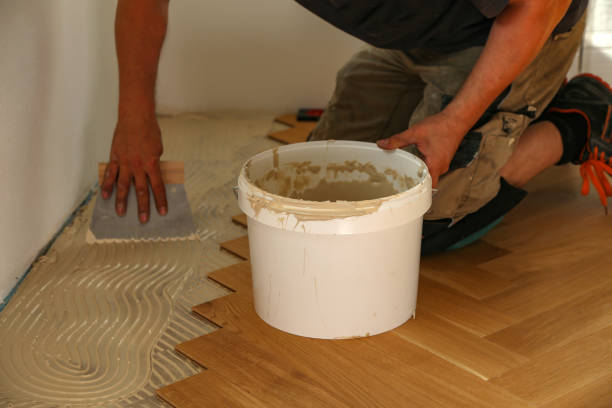 istock Worker laying parquet flooring. Worker installing wooden laminate flooring 1167643709