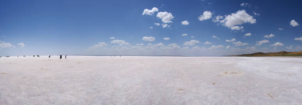 region zentralanatolien, türkei: menschen in der ferne zu fuß auf der salzfläche des tuz-sees, tuz golu, dem salzsee, dem zweitgrößten see der türkei und einem der größten hypersaline-seen der welt - hypersaline stock-fotos und bilder