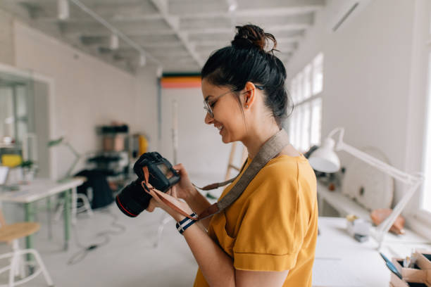Photographer working in a studio Photographer working in a studio camera photographic equipment stock pictures, royalty-free photos & images