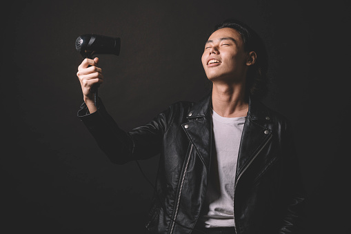 one asian chinese male model studio portrait with leather jacket cool attitude and black background