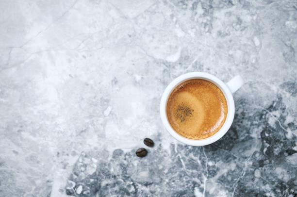 istock Cup of coffee and coffee beans on bright stone background. Directly Above. Copy space 1167644102