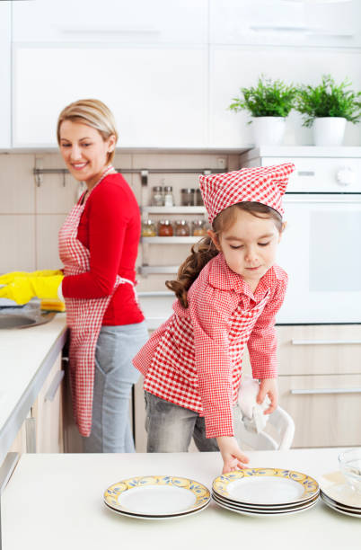 istock Mother and daughter washing dishes together 1167647720