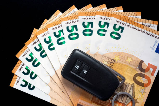 istock Key car on several 50 euro notes. Buy a car concept. view from above, black background. 1167651136