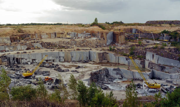 istock Granite stone mine with heavy equipment excavators loading raw rocks 1167651232