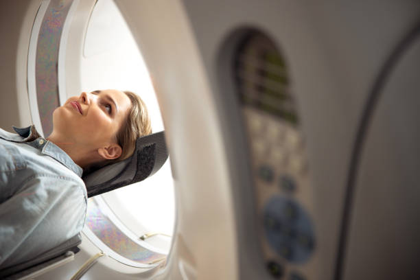 istock Smiling lady lying on CT scanner table at radiology clinic 1167655754