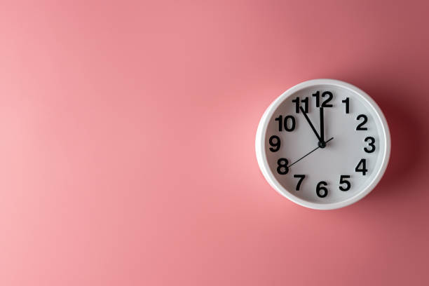 istock White clock on pink wall. Minimal time concept. Christmas or New Year minimal concept. 1167656690
