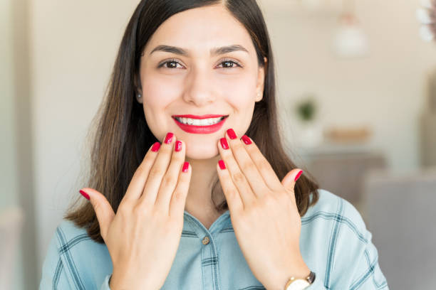 porträt der jungen frau glücklich mit ihren roten nägeln in spa - cosmetics nail polish beauty spa lipstick stock-fotos und bilder