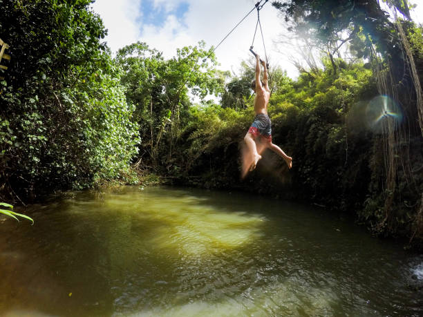 zip futter und fallen in schönen dschungel pools der heilung, schönes wasser von hawaii - ziplining zip line outdoors zip lining stock-fotos und bilder