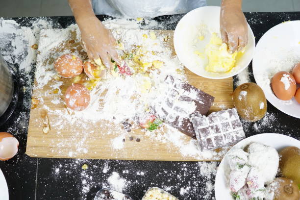 クローズアップ小麦粉の卵で遊ぶ手、ケーキを作る楽しみを持つ子供かわいい女の子、乱雑なキッチン。 - bread bakery women cake ストックフォトと画像