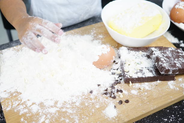 Close up Hand playing with flour eggs, kids cute girl having fun making cake, messy kitchen.
