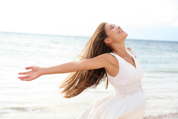 mujer relajándose en la playa disfrutando de la libertad de verano - beach sea zen like nature fotografías e imágenes de stock