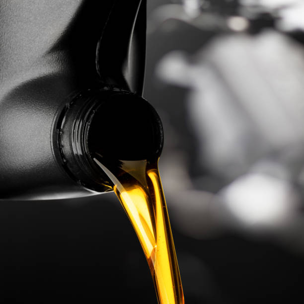 istock Pouring oil lubricant motor car from black bottle on engine background object transportation design 1167681234