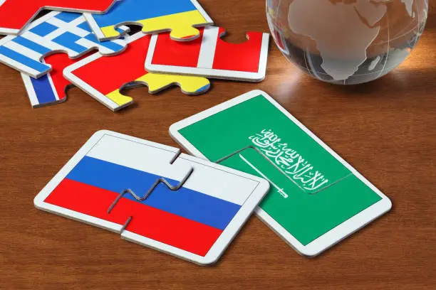 puzzle with the national flag of Russian and Saudi Arabia on wooden table