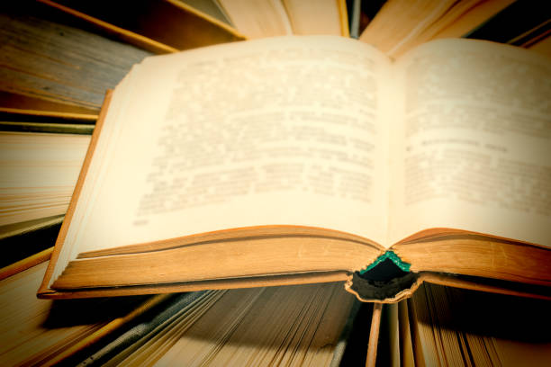 istock An old open book in a hard cloth cover, close-up. 1167686937