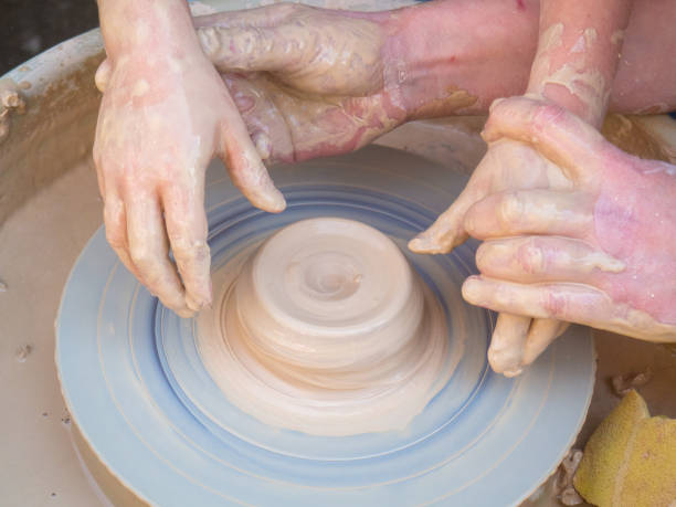 istock Master class on modeling of clay on a potter's wheel In the pottery workshop for children sunny day. 1167688038
