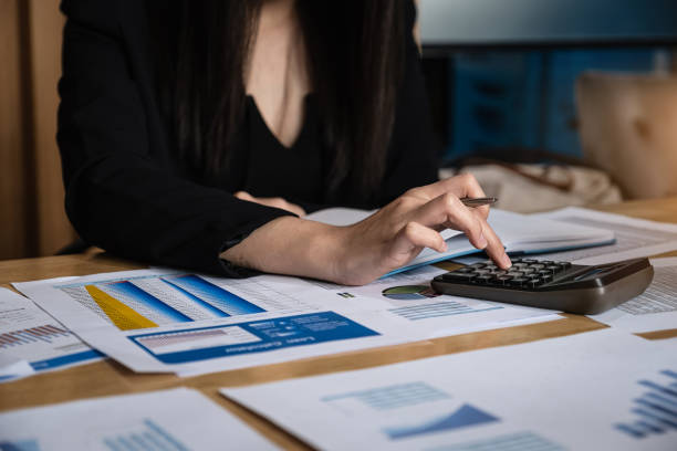 istock Business woman using calculator for analyze with stock data document. Business finance concept. 1167688143