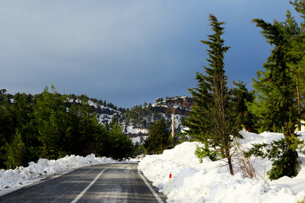 istock empty single lane road on snow covered mountainside 1167692915