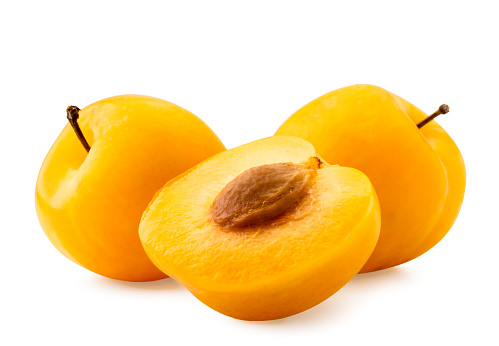 Yellow plums and half close up on a white background. Isolated.