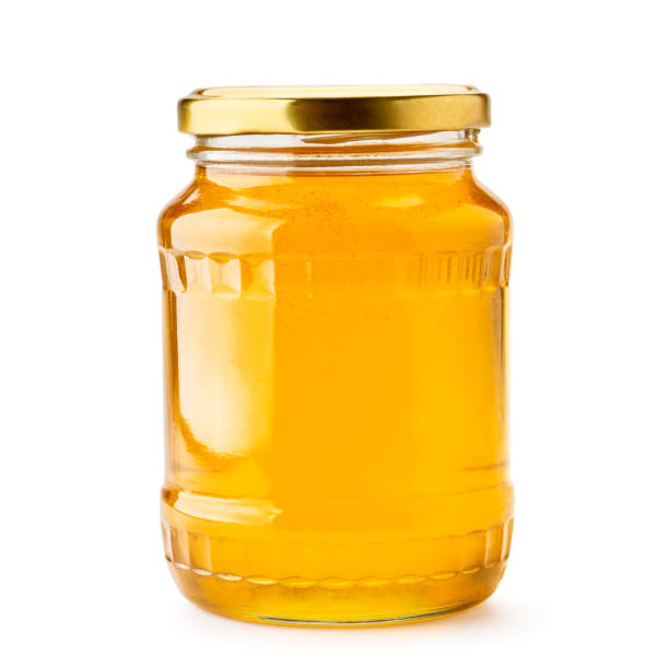 istock Honey in a glass jar close-up on a white. Isolated. 1167694079