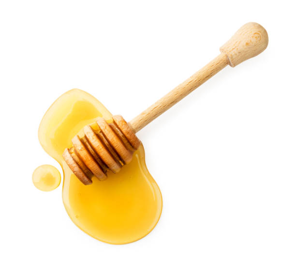 bastone con il miele su uno sfondo bianco. la vista dall'alto. - miele dolci foto e immagini stock
