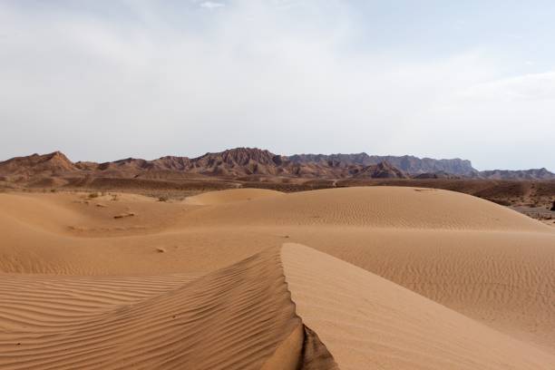 istock Dasht-e Kavir desert sand dunes with mountains on Horizon, Iran. 1167698813