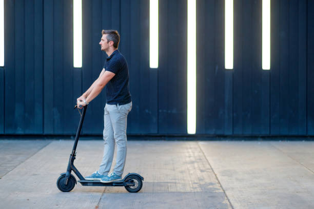 istock Commuter riding e-scooter on the patio by the wall 1167701347