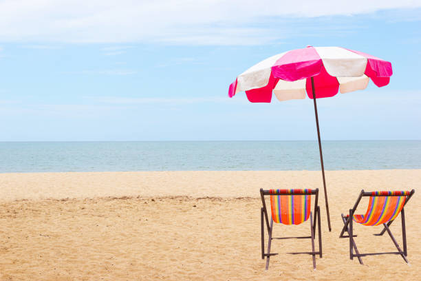 istock Beach Pink umbrellas with Empty chairs on a sandy sea beach Thailand 1167701433