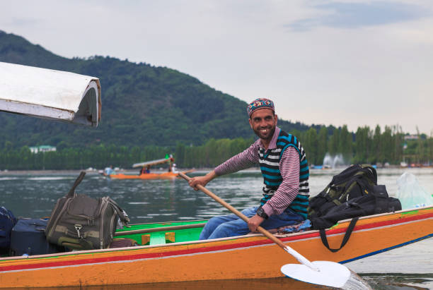 happy boatman on the move unidentified boatman feeling happy as tourists are on his boat at Dal Lake, Jammu and Kashmir, India on June 22, 2018 lake nagin stock pictures, royalty-free photos & images