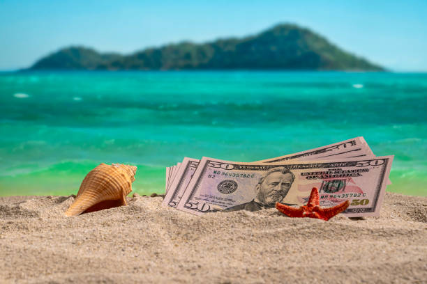 Banknotes of 50 dollars on the beach at sunset.