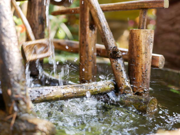 istock Selective focus of water drops falling from a bamboo hydraulic turbine onto a water surface and splashing in different directions 1167701685