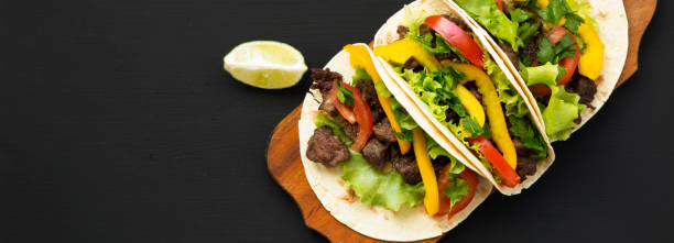 istock Beef tacos. Corn tortillas on a black background, overhead view. Top view, from above. Copy space. 1167704158