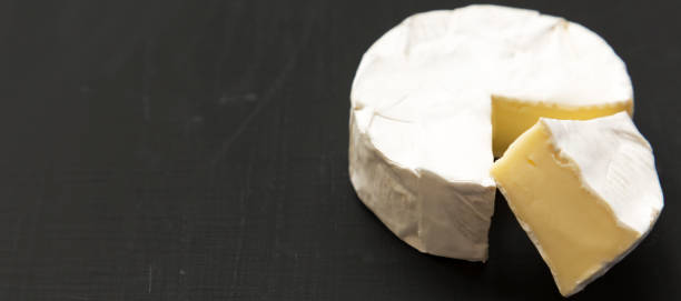 istock Cheese camembert or brie on a black background. Milk production. Side view. Close-up. Space for text. 1167704276