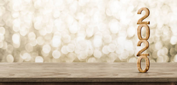 bois heureux de nouvel an 2020 avec l'étoile étincelante sur la table en bois brun avec le fond de bokeh d'or, concept de célébration de fête de vacances. bannière maquette pour l'affichage du contenu du produit ou de la conception. - new year wall decoration gift photos et images de collection